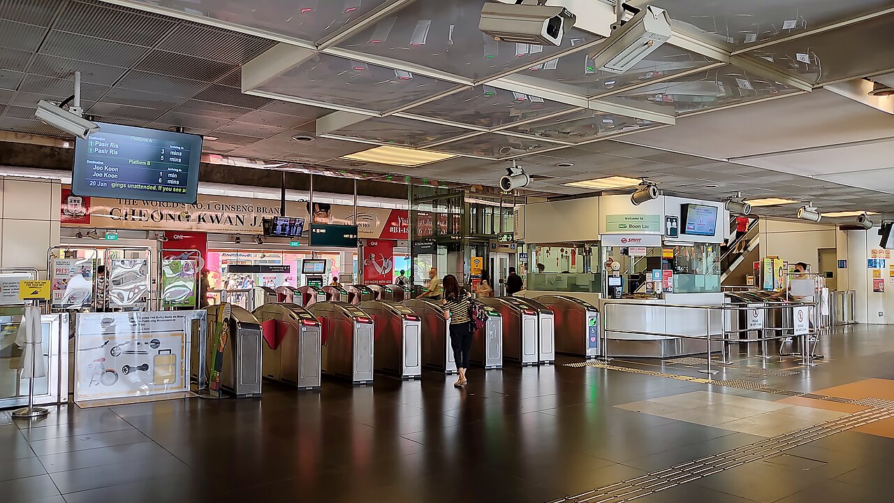 Ruang lobi stasiun dengan lantai bergaris pemandu dan papan penunjuk
